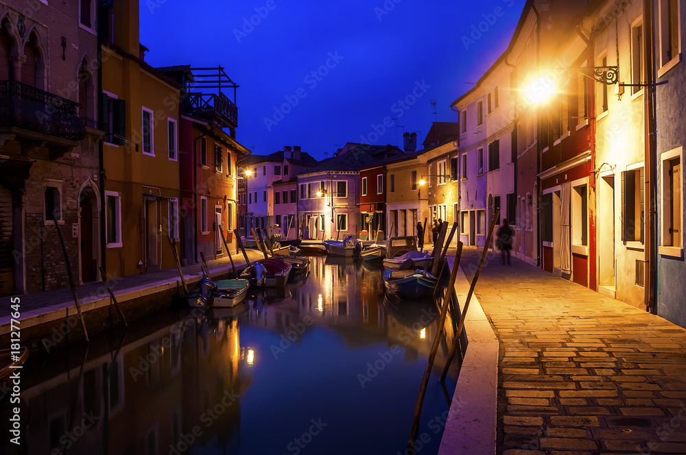 Beautiful evening cityscape of Burano island in Venice. Colored buildings are illuminated by ...