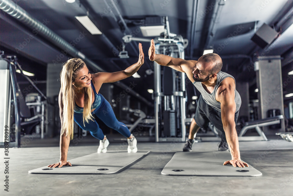 Sport Couple Doing Plank Exercise Workout In Fitness Centrum. Man And Woman Practicing Plank In ...