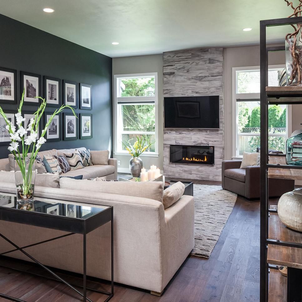 The dark accent wall, fireplace and custom wood floors add warmth to this open, modern living ...