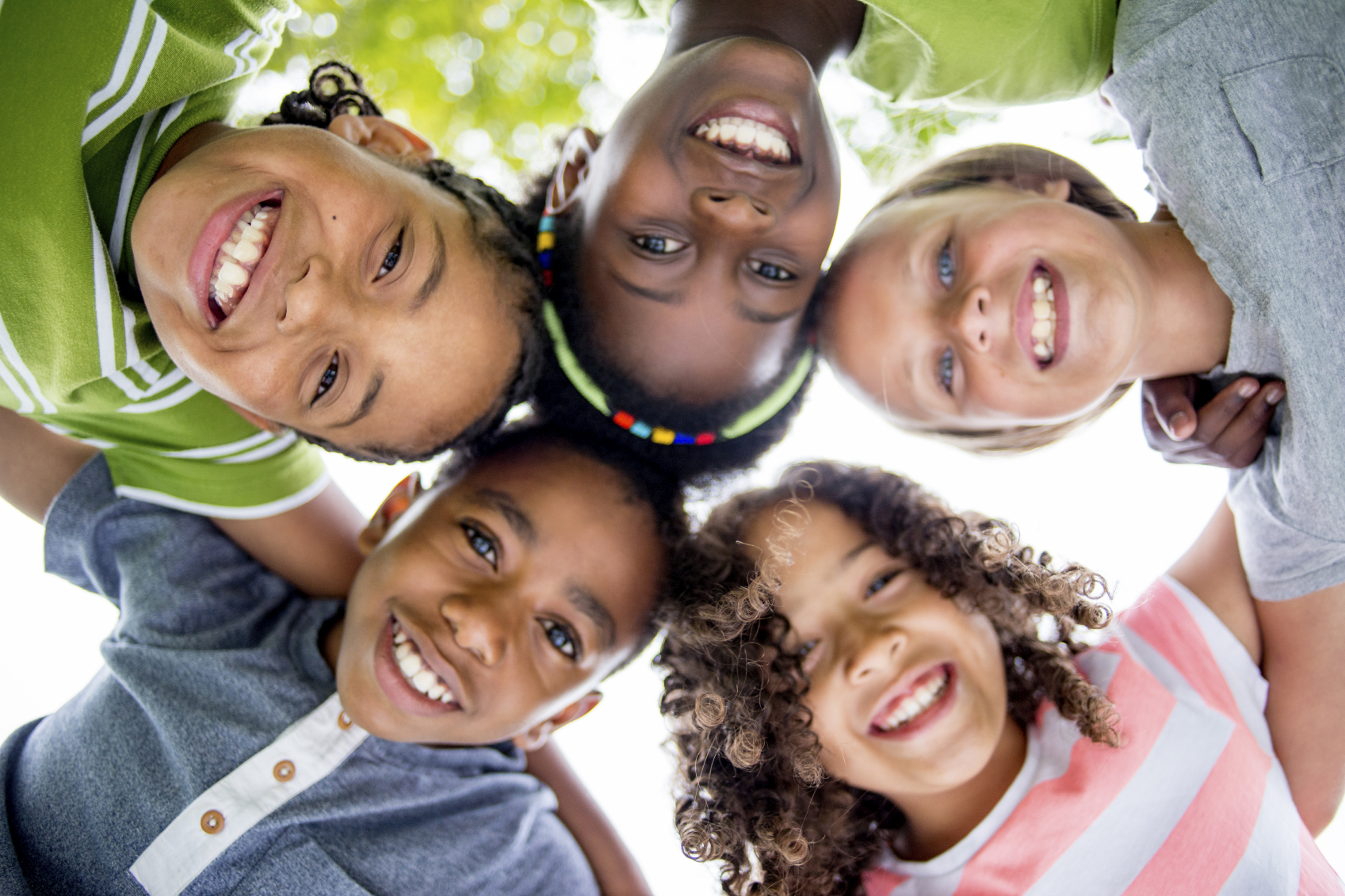 Children Smiling in a Huddle - Distinguished Dental Blog