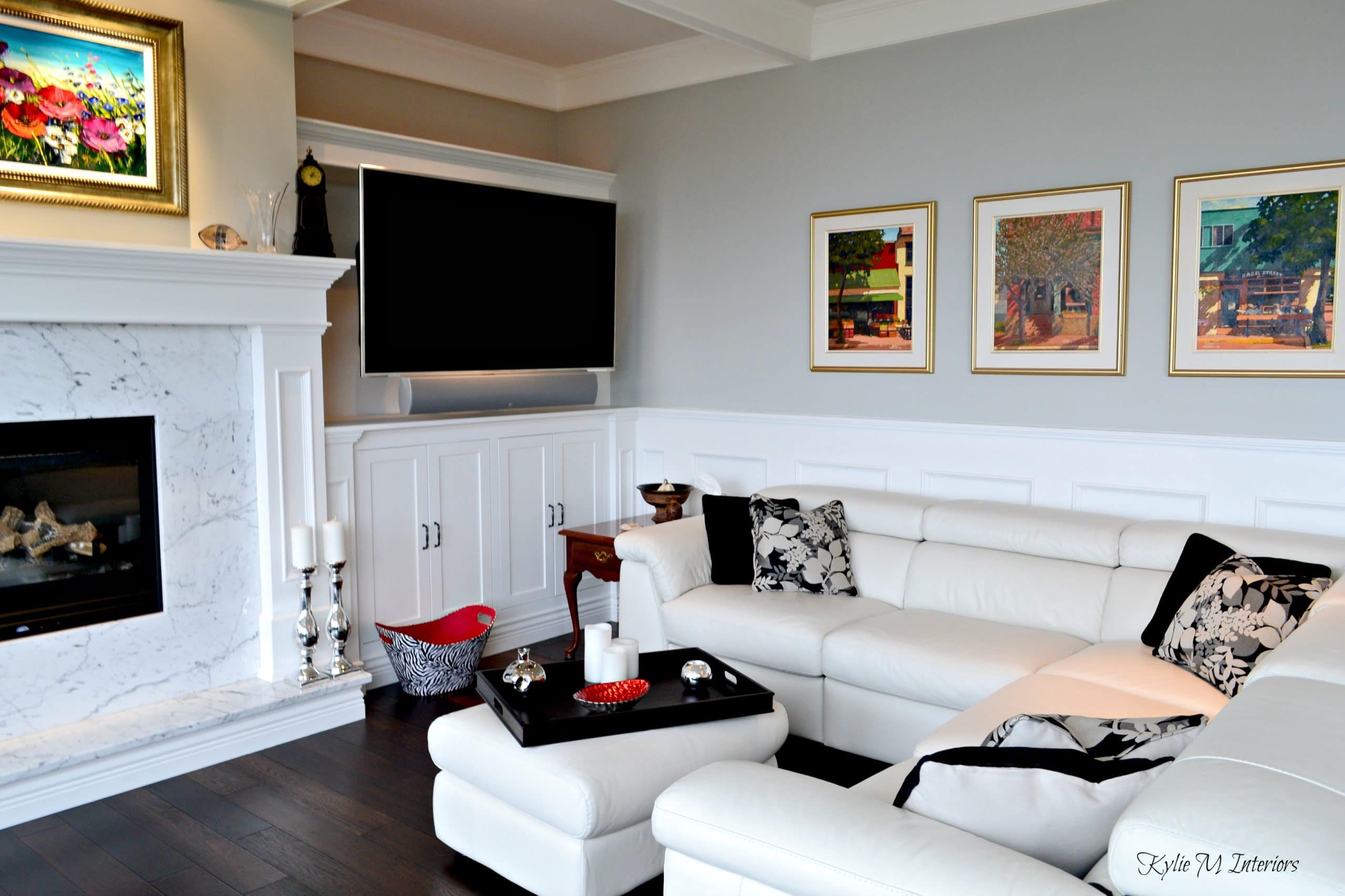 Living room with built in tv cabinet, marble fireplace surround, wainscoting and white sectional ...